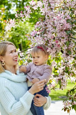 Anne ve kızı bahar parkında doğa yürüyüşünde. Küçük kız ve anne hafta sonu aktivitelerinde iyi vakit geçiriyorlar.