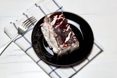 Tabakta bir dilim lezzetli çikolatalı pasta var. Ahşap arka planda lezzetli bir tatlı, yakın planda.