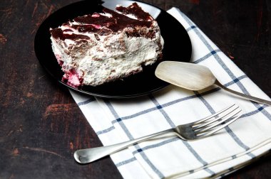 Tabakta bir dilim lezzetli çikolatalı pasta var. Ahşap arka planda lezzetli bir tatlı, yakın planda.