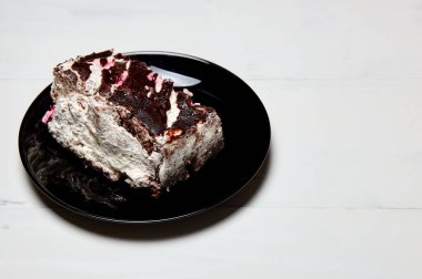 Tabakta bir dilim lezzetli çikolatalı pasta var. Ahşap arka planda lezzetli bir tatlı, yakın planda.