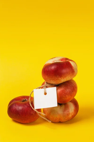 Ripe nectarine with label on the yellow background
