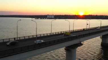 Spor arabanın en üst hava manzarası gün batımında nehrin üzerindeki araç köprüsünde. Arkadaşlarla araba gezisi. Macera Zamanı