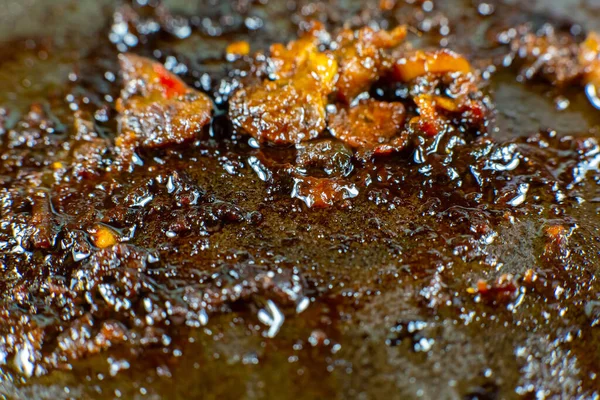 Burnt pan with oil. Fat leftovers close up. Unhealthy food. Damaged kitchenware.