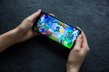 LVIV, UKRAINE - 25 Ekim 2020: Modern akıllı telefon üzerinde mobil oyun Levelhead oynamak.