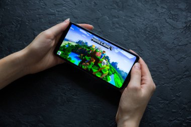 LVIV, UKRAINE - 25 Ekim 2020: Modern akıllı telefonda mobil oyun Minecraft oynamak.