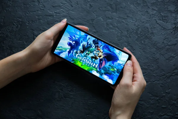 LVIV, UKRAINE - 25 Ekim 2020: Modern akıllı telefon üzerinde mobil oyun Genshin etkisi.