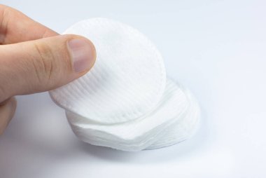 Beyaz arka planda beyaz pamuklu sünger tutan adam. Fotoğrafı kapat. Güzellik, ilaç ve kozmetik prosedürleri.
