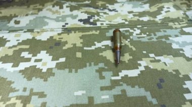 Mermiler ve mermi kovanları eski haki rengi ceketin üzerine düşer.. 