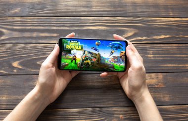 LVIV, UKRAINE - 25 Ekim 2020: Modern akıllı telefonda mobil oyun Battle Royal Fortnite oynamak.