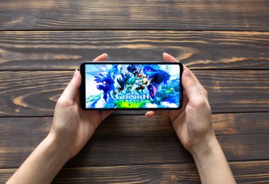 LVIV, UKRAINE - 25 Ekim 2020: Modern akıllı telefon üzerinde mobil oyun Genshin etkisi.