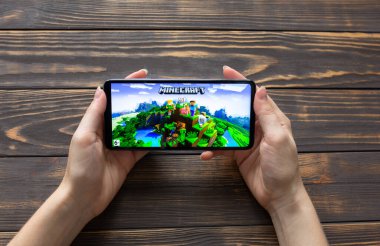LVIV, UKRAINE - 25 Ekim 2020: Modern akıllı telefonda mobil oyun Minecraft oynamak.