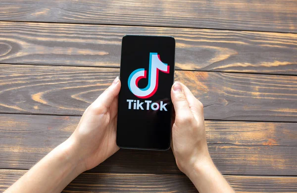 LVIV, UKRAINE - 25 Ekim 2020: Tik Tok uygulaması modern akıllı telefonda. Sosyal ağlar. Ahşap arkaplan.