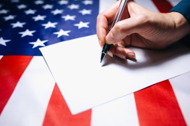 Kadın oy için kağıda kene koyuyor. Ülkedeki politik değişiklikler. Boşluğu kopyala. Amerika 'da seçimler. Amerikan bayrağı. İnsanlar oy pusulasında oy kullanıyor.