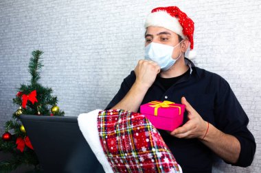 İnsan işaret dili ile iletişim kuruyor. Bilgisayarın yanındaki Noel Baba şapkalı adam görüntülü konuşmalarla iletişim kuruyor. Özürlü olarak yaşa. Noel 'i evde yalnız geçireceğim. Tatil için sosyal uzaklık.