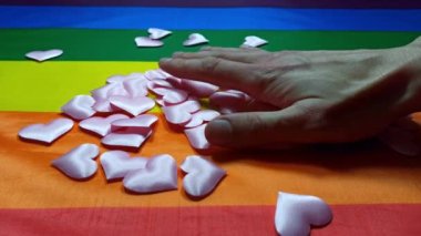 Lgbt topluluğunun renkli bayrağı. Gökkuşağı arka planında pembe kalpler. Lezbiyen ve gey sorunları. Evliliğin homoseksüel yönelimli çiftler için yasallaştırılması. Eşitlik kavramı.