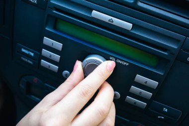 Kadın arabanın radyosunun sesini açıyor. Kız sürüyor..