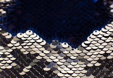 Yuvarlak pullu altın tekstil. Pul pul parlayan kumaş, yakın plan fotoğraf. Kıyafetler ve çantalar için retrokumaş. Tatil parlak renk konsepti. Lüks moda..