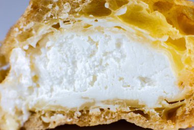 Beyaz tabakta kremalı kek. Kahvaltıda tatlı. Kesilen pastanın yarısının görüntüsünü kapat.