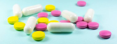 Yeşil arka planda renkli haplar ve tabletler. Kapatın. Tıbbi tedavi kavramı.