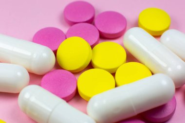 Pembe arka planda renkli haplar ve haplar. Kapatın. Tıbbi tedavi kavramı.