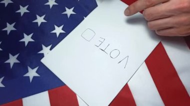 Adam oy için kağıda tik koyuyor. Ülkedeki politik değişiklikler. Boşluğu kopyala. Amerika 'da seçimler. Amerikan bayrağı. İnsanlar oy pusulasında oy kullanıyor.