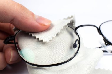 Okuma gözlüğünü bezle temizleyen kadın. Fotoğrafı kapat..