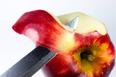 Beyaz arka planda bir bıçakla bir elmayı soymak. Fotoğrafı kapat..