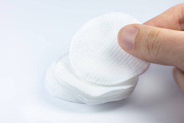 Beyaz arka planda beyaz pamuklu sünger tutan adam. Fotoğrafı kapat. Güzellik, ilaç ve kozmetik prosedürleri.