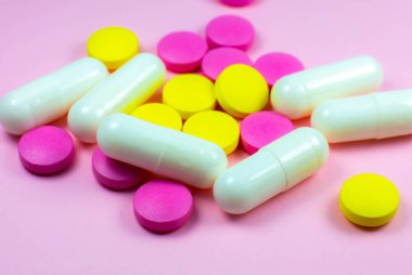 Pembe arka planda renkli haplar ve haplar. Kapatın. Tıbbi tedavi kavramı.