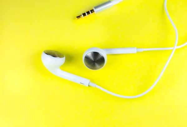 Белые Наушники Лежат Желтом Фоне Концепция Современной Музыки Аудио Технологии — стоковое фото