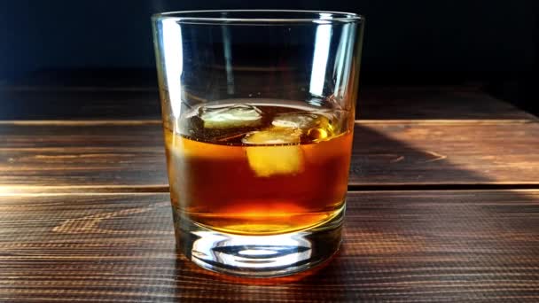 Van Dichtbij Gezien Menging Van Whiskey Ijsblokjes Glas Houten Tafel — Stockvideo