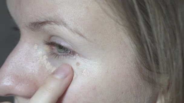 目の下の滑らかな顔の皮膚にシーラーを適用する若い女性 家にいて 近くにいて — ストック動画