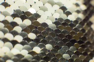 Yuvarlak pullu altın tekstil. Pul pul parlayan kumaş, yakın plan fotoğraf. Kıyafetler ve çantalar için retrokumaş. Tatil parlak renk konsepti. Lüks moda..