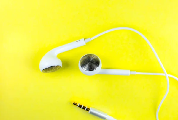 Białe Słuchawki Leżące Żółtym Tle Koncepcja Muzyki Nowoczesnej Technologia Audio — Zdjęcie stockowe