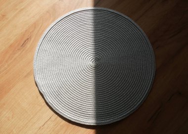 Masadaki gri pamuklu peçete. Gölgeli masa örtüsü. Sabah güneşi ışığı.