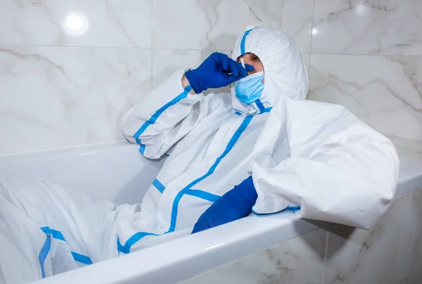 医生穿着医用防护服 面罩和手套躺在浴缸里 下班后放松 按病毒流行情况分列的防护人员 Coronavirus Covid 保健概念 — 图库照片