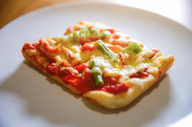 Yumuşak odaklı fotoğraf. Ev yapımı sebzeli pizza, jambon ve peynir. En iyi İtalyan mutfağı. En sevdiği yemek. Karantina zamanında yemek pişirme.