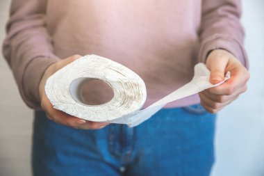 Tuvalet kağıdı rulosunu tutan kadın. Koronavirüs hastalarının karantina sırasındaki izolasyonları.
