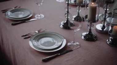 Bardaklar ve tabaklar ziyafet masasında. Süslü bir restoranda gece partisi. Kutlama zamanı, bayramlarda kutlama etkinliği. Masalarda güzel süslemeler. 