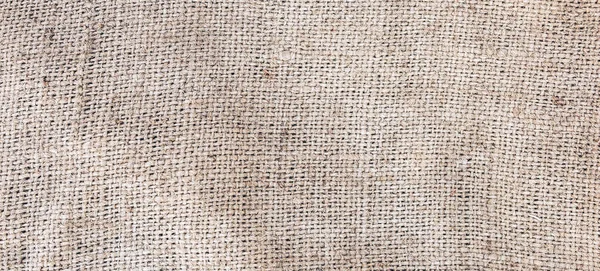 Old vintage linen cloth textile. Burlap rustic tumbled texture background.