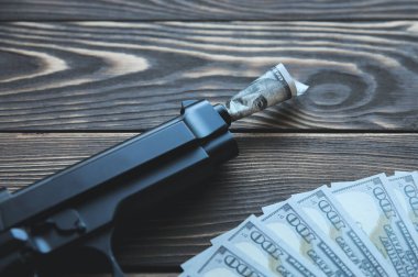 Para ve silah tahta arka planda yatıyor. Dünyayı dolar yönetiyor. Yozlaşmış dünya. Açgözlülük cinayeti.