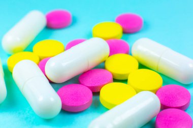 Yeşil arka planda renkli haplar ve tabletler. Kapatın. Tıbbi tedavi kavramı.