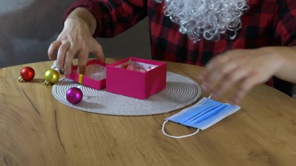 Papai Noel Está Embrulhando Máscara Médica Protetora Uma Caixa Presente — Vídeo de Stock