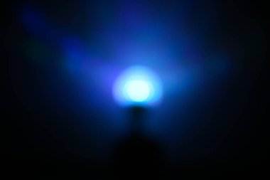 Yerde duran çok güzel bir gece lambası. Duvarlarda mavi gölgeler var. Bulanık odak.