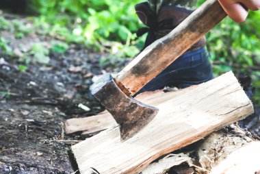 Adam dışarıda odun kesiyor. Baltalı bir turist..