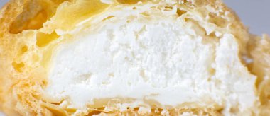 Beyaz tabakta kremalı kek. Kahvaltıda tatlı. Kesilen pastanın yarısının görüntüsünü kapat.