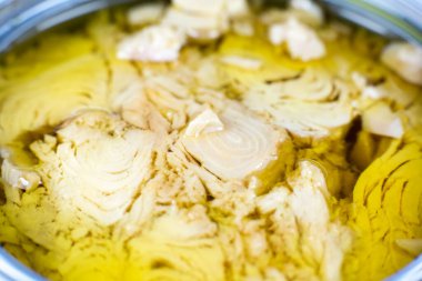 Beyaz arka planda yağlı konserve ton balığı eti. Kutu açıldı, resmi kapat..