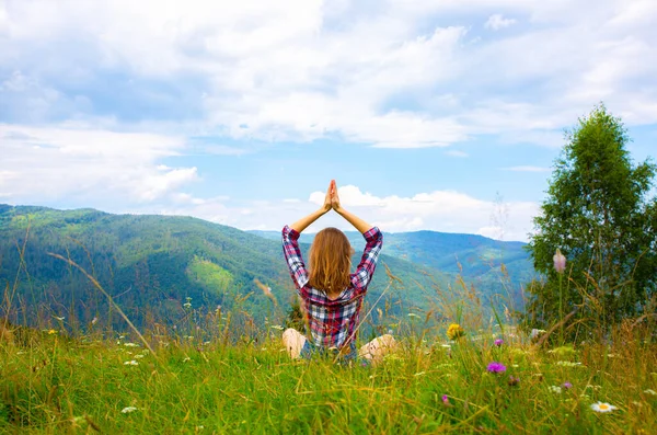 Yoga in the mountains. Beautiful girl is meditating in asana. amazing summer nature around. Harmony and wanderlust concept. Hipster travelling. Stylish woman enjoying life.