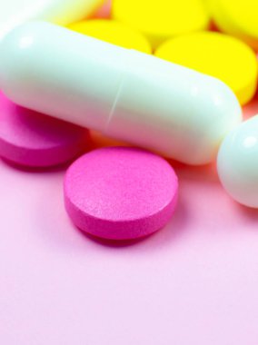 Pembe arka planda renkli haplar ve haplar. Kapatın. Tıbbi tedavi kavramı.