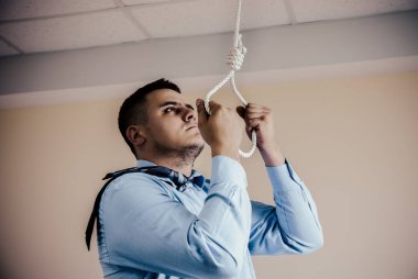 Ellerinde ilmeği olan bir ofis çalışanı. İntihar konsepti. İş stresi yüzünden asılmış. Bitkinlik bunalımı. Korkunç bir hayat durumu. İnsan hayatını seçer..